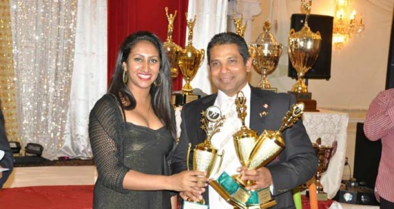 Former Guyana player Sunil Dhaniram collects three trophies from the OMSCL president’s daughter, for scoring three centuries