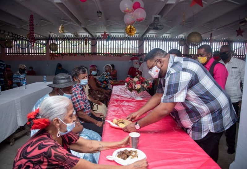 President Irfaan Ali serving lunch to the elderly at the Dharm Shala's 2020 Luncheon