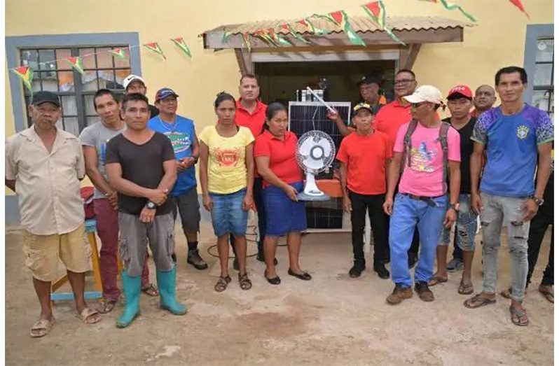 Minister of Housing and Water Collin Croal flanked by regional officials and residents during the distribution of the solar panels in Region One