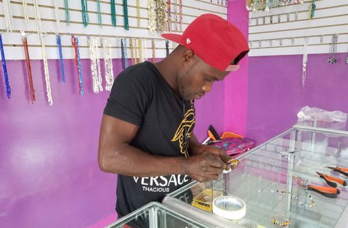 A staff in the process of creating an intricate bracelet made to order.