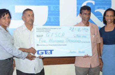 Here you go, sir! GT&T’s Marketing Officer Nicola Duggan (left) hands over the cheque to Ramchand Ragbeer and Dharam Persaud, while Margaret Washington (right) looks on appreciatively.