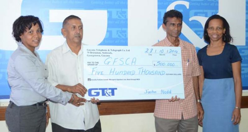 Here you go, sir! GT&T’s Marketing Officer Nicola Duggan (left) hands over the cheque to Ramchand Ragbeer and Dharam Persaud, while Margaret Washington (right) looks on appreciatively.