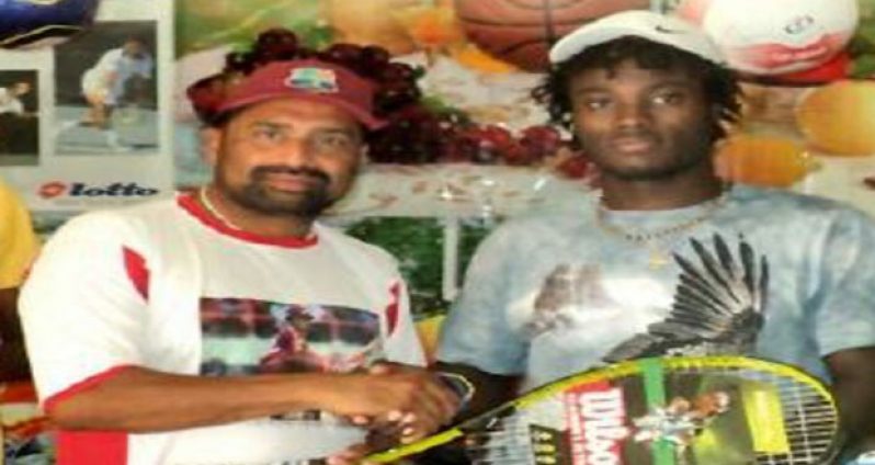 Khan (left) makes a donation of tennis equipment through West Indian Sports Complex to top seeded Jeremy Miller in 2011.