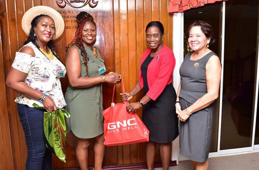 donate Carol Felix-Bathersfield presents a hamper to Clonel Samuels-Boston, Coordinator of WAD in the presence of First Lady Sandra Granger (first, right) and Melanie Bryan-Bathersfield, at State House