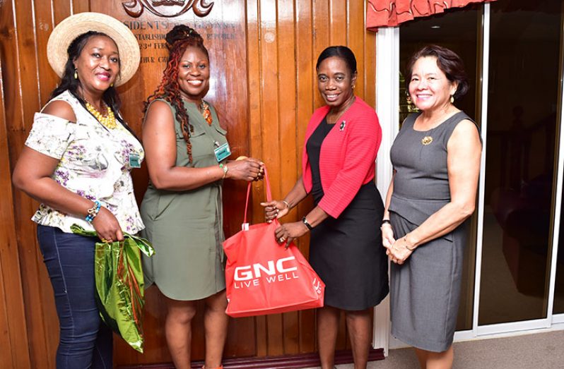 Carol Felix-Bathersfield presents a hamper to Clonel Samuels-Boston, Coordinator of WAD in the presence of First Lady Sandra Granger (first, right) and Melanie Bryan-Bathersfield, at State House