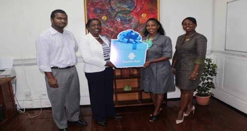 Minister Nicolette Henry receiving the cheque from Republic Bank Manager Celine Davis