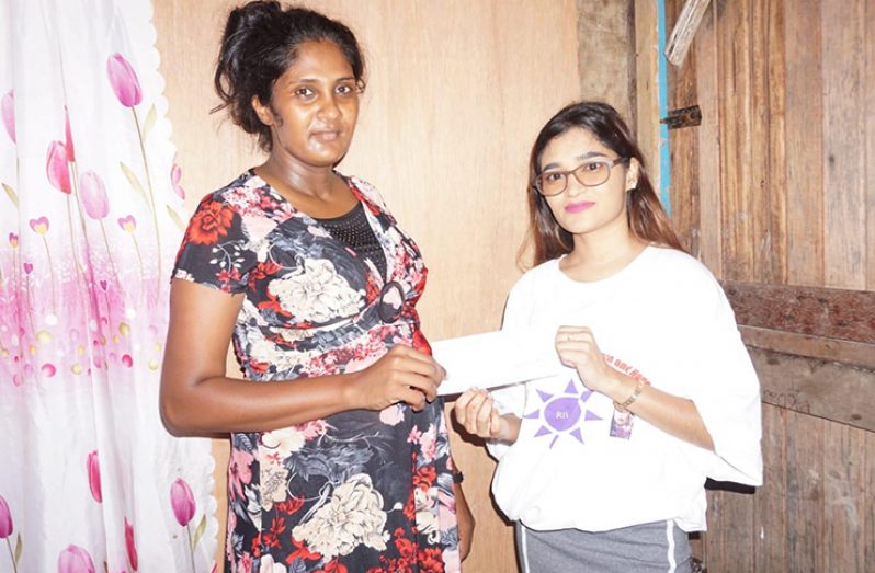 Madhuri Orilall receives a cheque from one of RIVAH representatives