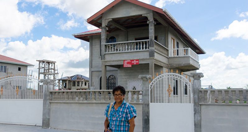 Ramdai Janet Dorie, 64, stands in front of her incomplete home