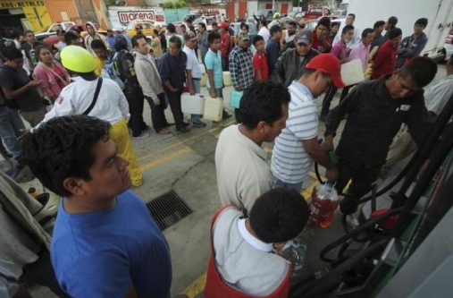 People wait in line to fill containers with gasoline at a gas station in Oaxaca, Mexico, June 5, 2015. REUTERS/Jorge Luis Plata
