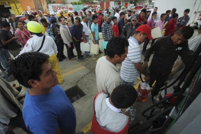 People wait in line to fill containers with gasoline at a gas station in Oaxaca, Mexico, June 5, 2015. REUTERS/Jorge Luis Plata