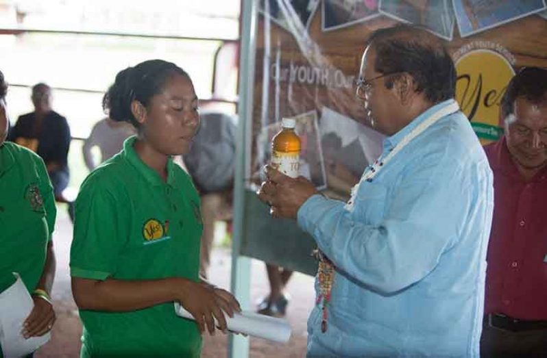 One of the Davis sisters presented a bottle of their honey to Prime Minister Moses Nagamootoo