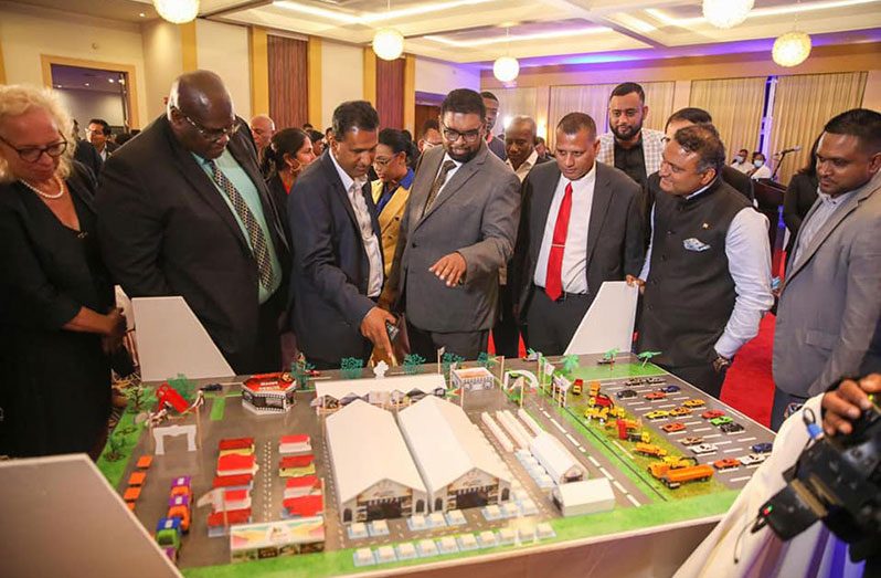 President, Dr. Irfaan Ali (fourth from left) and Minister of Housing and Water, Collin Croal (third from right) along with others examine a 3D model of what the Building Expo event is expected to look like (DPI photo)