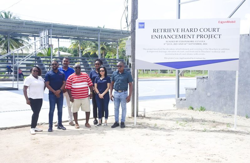 Officials from ExxonMobil, Cerulean Inc stand next to the rehabilitated Retrieve Hard Court