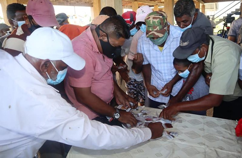 Minister Mustapha distributing seeds to farmers during his outreach to Leguan