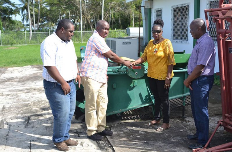 Minister within the Ministry of Agriculture with responsibility for Rural Affairs, Valerie Adams-Yearwood, hands over a harvesting machine to Regional Agriculture Officer of Region 9, Dr. Darren Halley. Also, in photo are Chief Technical Officer George Jervis and Gavin Glen, Technical Officer of the Rural Affairs Secretariat