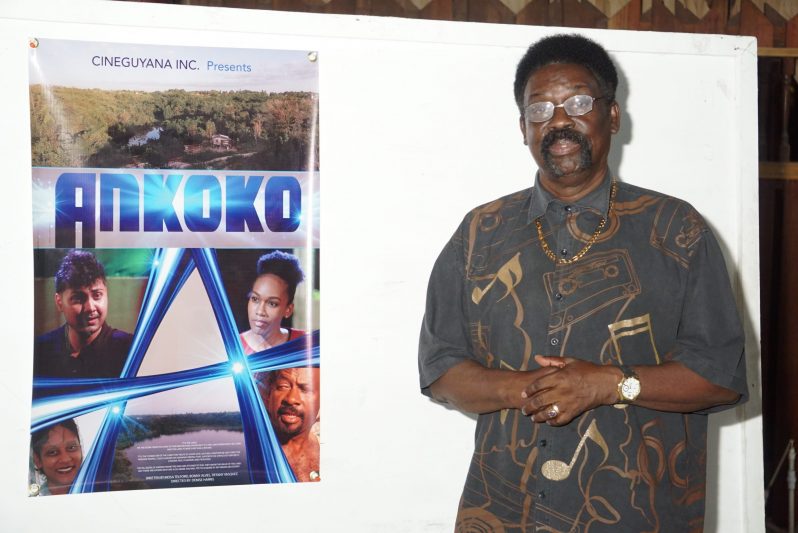 Renowned singer, song writer producer Bonny Alves, posing next to a poster of the film, Ankoko. Alves is one of the writers and producers of the film