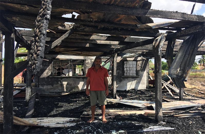 A distraught Baijnauth Baichand is surrounded by ashes after his home was destroyed by fire