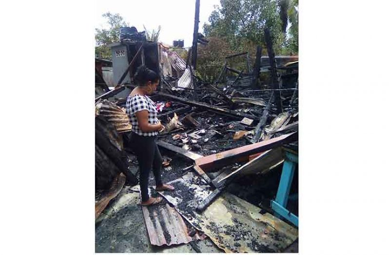 Rawattie Goberdhan looks over at the burnt building where her deceased mother once lived