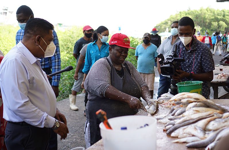Agriculture Minister, Zulfikar Mustapha, listening to the concerns of a vendor at the Meadow Bank Wharf on Tuesday (Carl Croker photo)