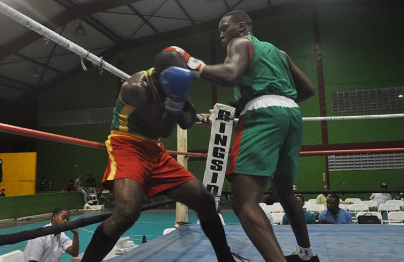 GDF’s Colin `Superman’ Lewis (right) storms forward with a flurry of combinations to the body and head of VBG’s Aubrey Moore in their junior welterweight contest on Saturday night (Photo by Delano Williams).