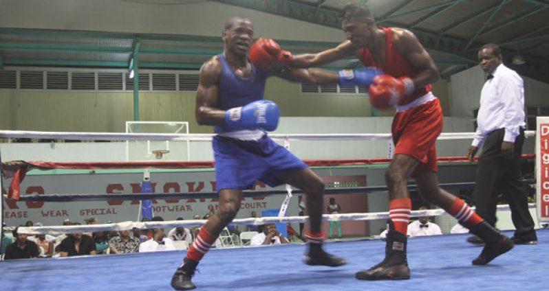 Imran Khan (right) connects to the jaw of his Guyanese counterpart Clairmont Gibson with a straight right in the final of the 60kg division which he won. (Sonell Nelson photo)