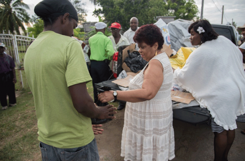 Minister of Social Protection, Hon. Amna Ally distributing items to the residents.