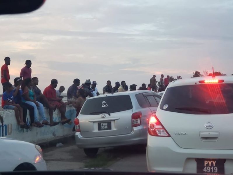 Several persons gathered at the Kitty seawall on Sunday afternoon (Fareeza Haniff Photo)