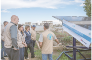 FAO Deputy Director-General Beth Bechdol (third left), Assistant Director-General and Regional Reprsentative for the Near East and North Africa, AbdulHakim Elwaer (fourth from left) Director of Emergencies Rein Paulsen (left), FAO Representative in Lebanon Veronica Quattrola (second from left) stand next to the solar array during a field visit in Lebanon to meet a group of farmers who are using an innovative shared solar-powered irrigation pump to irrigate their greenhouses