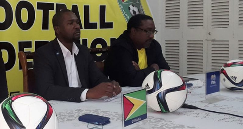 Guyana Football Federation president Wayne Forde (left) addresses media operatives at yesterday’s press conference. At right is Golden Jaguars head coach Jamaal Shabazz.