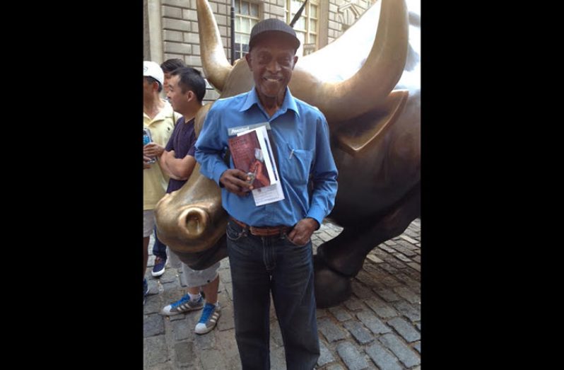 Francis Quamina Farrier pictured with the Wall Street Bull in the Downtown Manhattan Financial District of New York City.