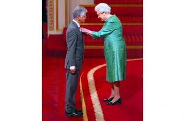 Queen Elizabeth ll, pinning the insignia of Member of the British Empire (MBE) on Henry Muttoo at Buckingham Palace