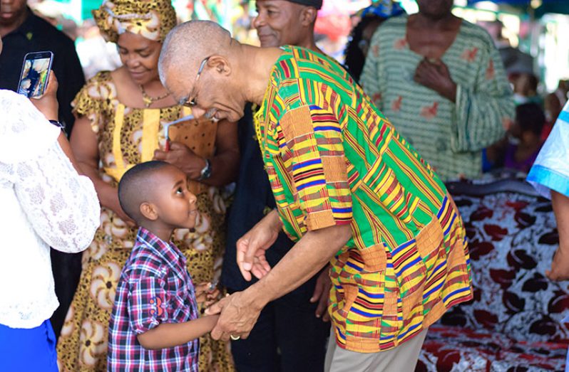President David Granger interacts with this lad during the Emancipation festivities at the Gibraltar-Fyrish Primary School on Tuesday
(Delano Williams photo)
