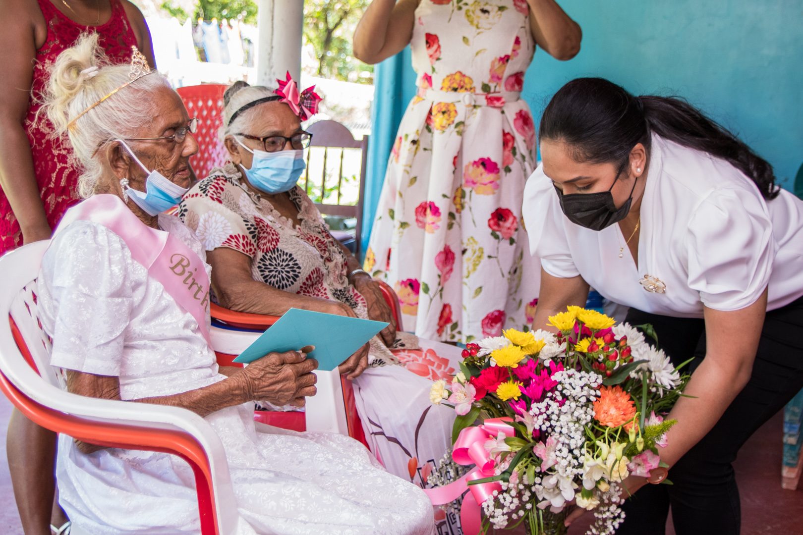 First Lady, Arya Ali, presents a bouquet to Aunty Ramdularie of Leguan, who turned 100 on Monday,
 in the presence of the centenarian’s family members (Office of the First Lady photo)