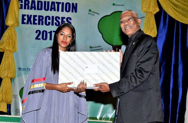 President David Granger presents a gift to Best Graduating Student Nirupa Manroop at the Cyril Potter College of Education (CPCE) 83rd graduation exercise held at the National Culture Centre on Thursday (Ministry of the Presidency photo)