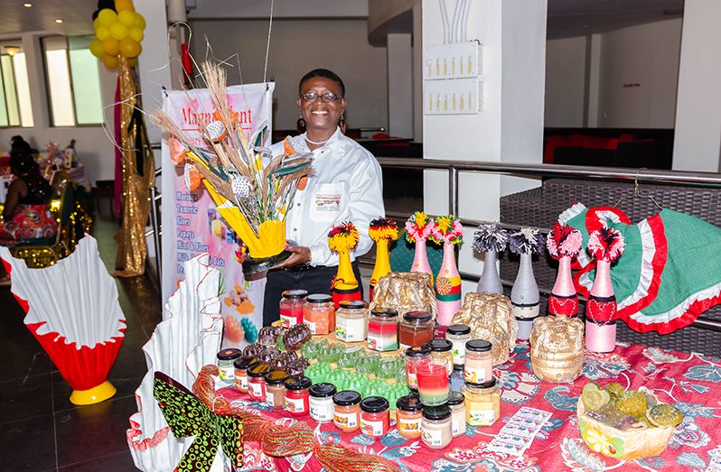 An exhibitor shows off one of her exhibits at the Women in Business Expo at the Pegasus Hotel on Friday (Delano Williams photo)