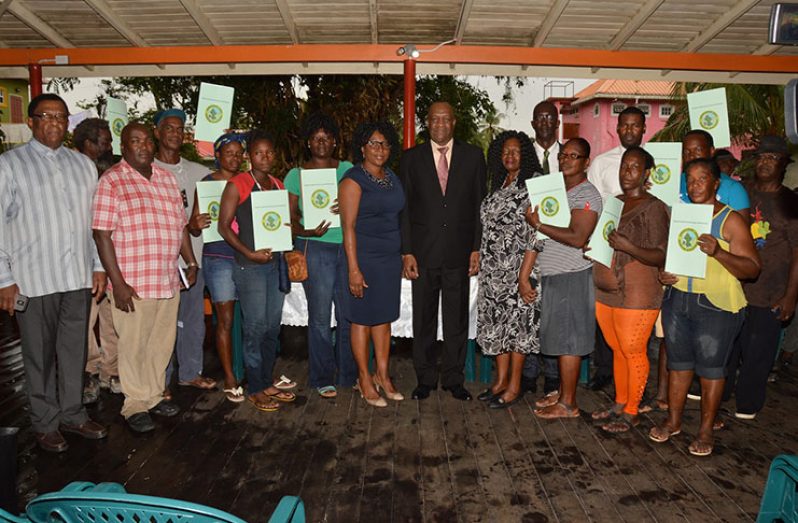 Minister of State Joseph Harmon and others with some of the beneficiaries of the ‘Permission to Occupy State Lands’ document for the Mocha/ Arcadia
community (Ministry of the Presidency photo)