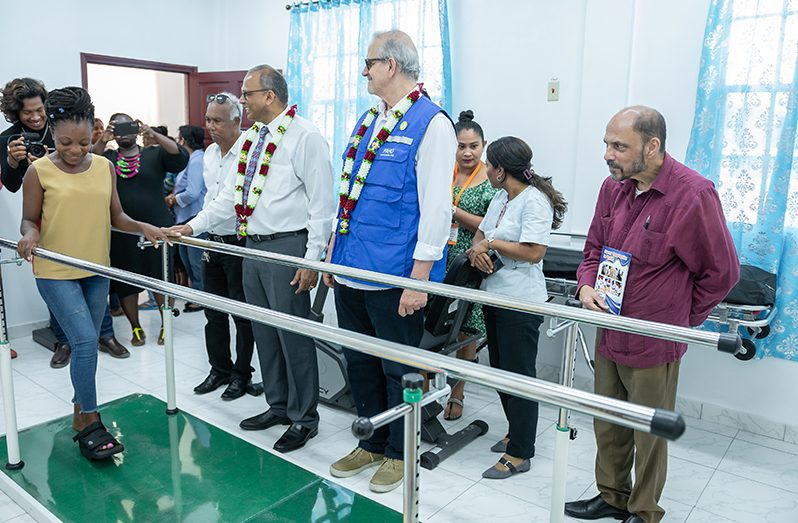 Minister of Health, Dr. Frank Anthony and other officials watch on as one of the employees conduct a demonstration inside the physiotherapy and rehabilitation service room (Delano Williams photo)