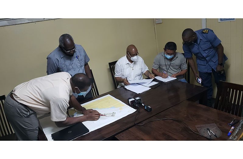 Home Affairs Minister, Robeson Benn (second left), and Public Works Minister, Juan Edghill (third right), with MARAD officials, at Maritime Boat House at
Stabroek Stelling, perusing information and maps pertaining to the vessel’s retrieval mission (Rabindra Rooplall photo)