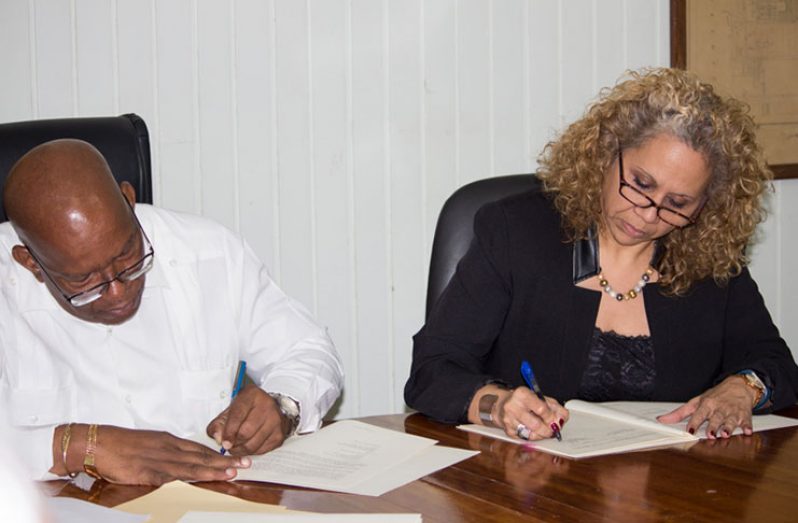 Finance Minister, Winston Jordan and IDB Country Representative,
Sophie Makonnen,sign the technical assistance agreements at the
Ministry of Finance on Monday