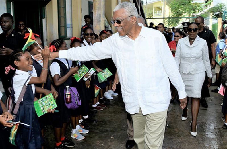 High Five! President David Granger greets pupils
of the St. John the Baptist Primary School Tuesday
morning during his visit to Bartica. Also in photo is
Minister of Education, Dr. Nicolette Henry