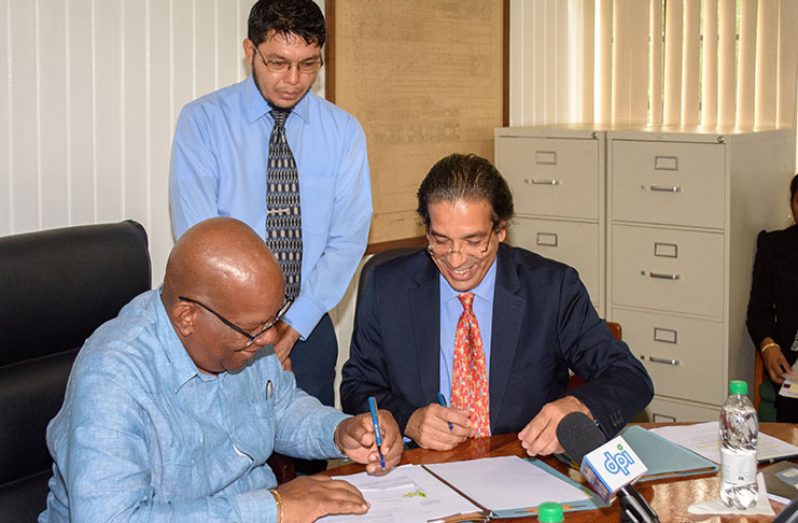 Minister of Finance, Winston Jordan and the World Bank’s Senior Country Officer for Guyana, Suriname and Belize,
Pierre Nadji, sign the loan agreement while another official looks on