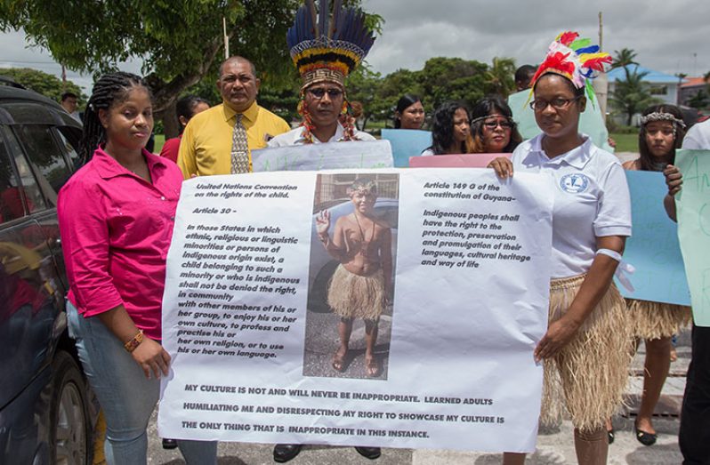 Indigenous organisations in Guyana and other citizens rallied around Karen Small (left) as she picketed Mae’s Primary
School on Tuesday over allegations that her nine-year-old son, Joshua Chacon, was rejected and condemned for wearing
an indigenous attire for the school’s culture day. Samuel Maughn photo)