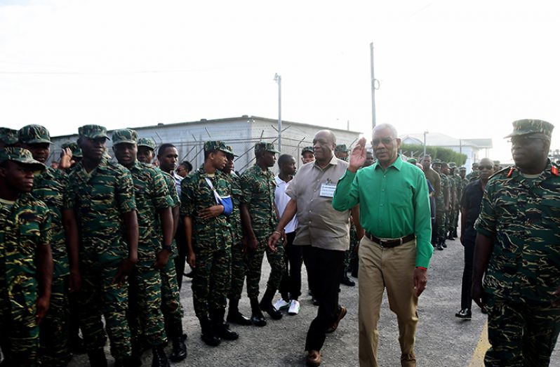 President David Granger and Director
General of the Ministry of the Presidency,
Joseph Harmon, walk past
ranks of the Guyana Defence Force
during their visit to Camp Ayanganna
on Friday to observe the voting process
(Adrian Narine photo)
