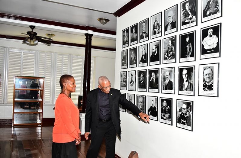 President David Granger guides Baroness Amos through a photographic display at State House on Wednesday (Ministry of the Presidency photo)