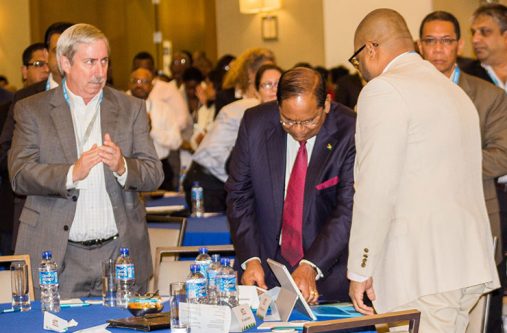 Jeff Simons , country Manager of ExxonMobil, applauds as
Prime Minister Moses Nagamootoo prepares to address the
gathering. Backing the camera is President of the Guyana
Oil and gas Association, Bobby Gossai Jr.