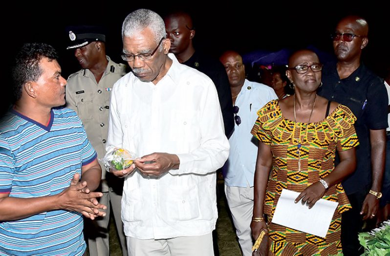 WEST Berbice Trade Expo: Secretary of the Region Five (Mahaica-Berbice) Chamber of Commerce and Industry and cash
crops farmer Sewlall Krishna show off some of his produce to President David Granger, who was at the time visiting the
booths at the second Expo and Trade Fair to be held in that region at the Bath Settlement Community Centre Ground.
(Ministry of the Presidency photo)
