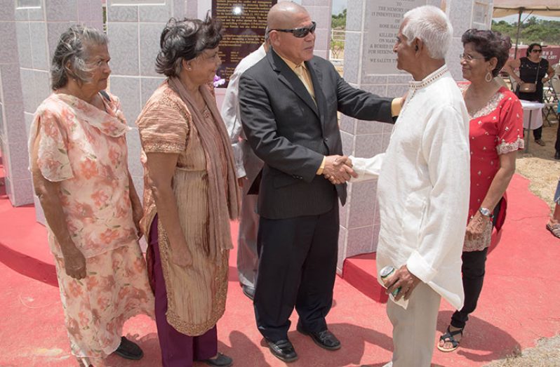 Minister of Social Cohesion with responsibility for Culture, Youth and Sport, Dr. George Norton interacts with Dr. Fred
Sukdeo as Ms. Devi Sukdeo (second, from left) and Ms. Pamela Sukdeo-Badley (right) the grandchildren of one of the slain
workers look on
