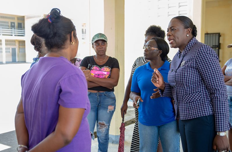 Minister of Education Nicolette Henry engages parents and teachers on the sidelines of a meeting at the Hope Secondary School
(Delano Williams photo)