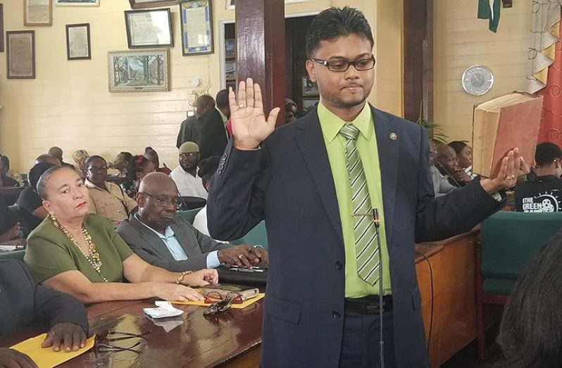 New Mayor of Georgetown, Pandit
Ubraj Narine taking the oath of office
on Friday. In the background are
former Mayor, Patricia Chase-Green
and Councillor Oscar Clarke