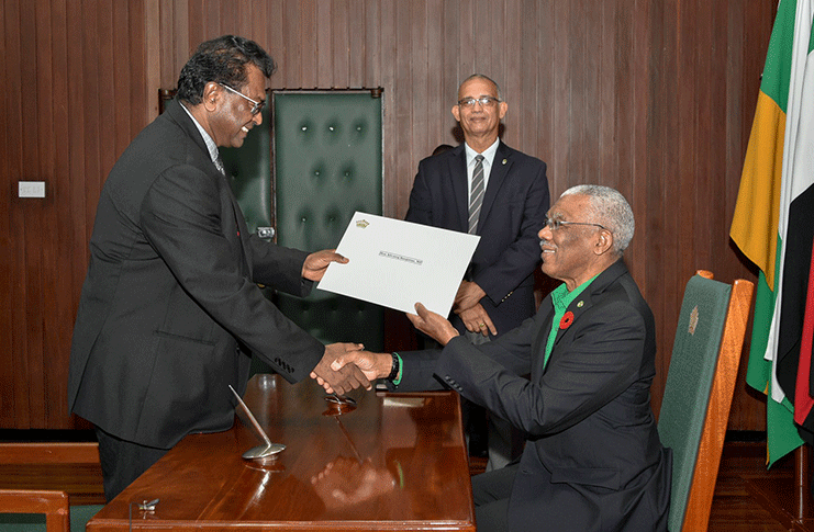 President David Granger on Wednesday swore in Minister of Public Security, Mr. Khemraj Ramjattan, to perform
the duties of Prime Minister. Prime Minister Moses Nagamootoo is currently overseas. In this photo, President Granger
presents Mr. Ramjattan with his Instrument of Appointment